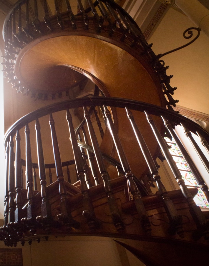 An intricately-carved wooden spiral staircase with no central pillar