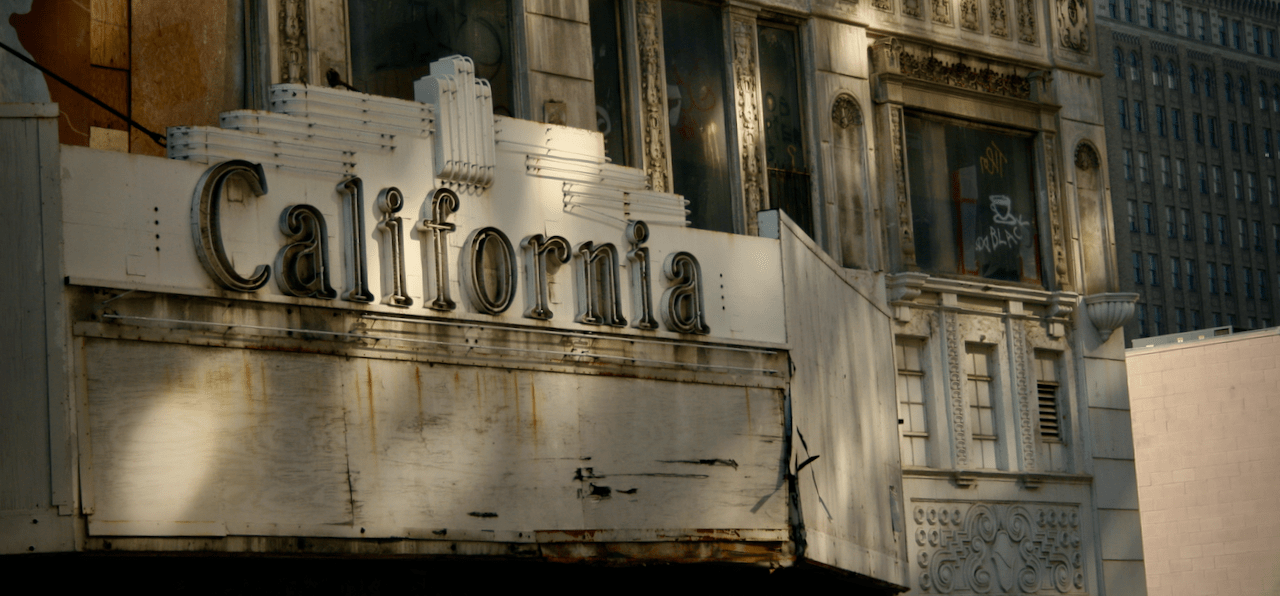 Boarded-up theater with 'California' marquee