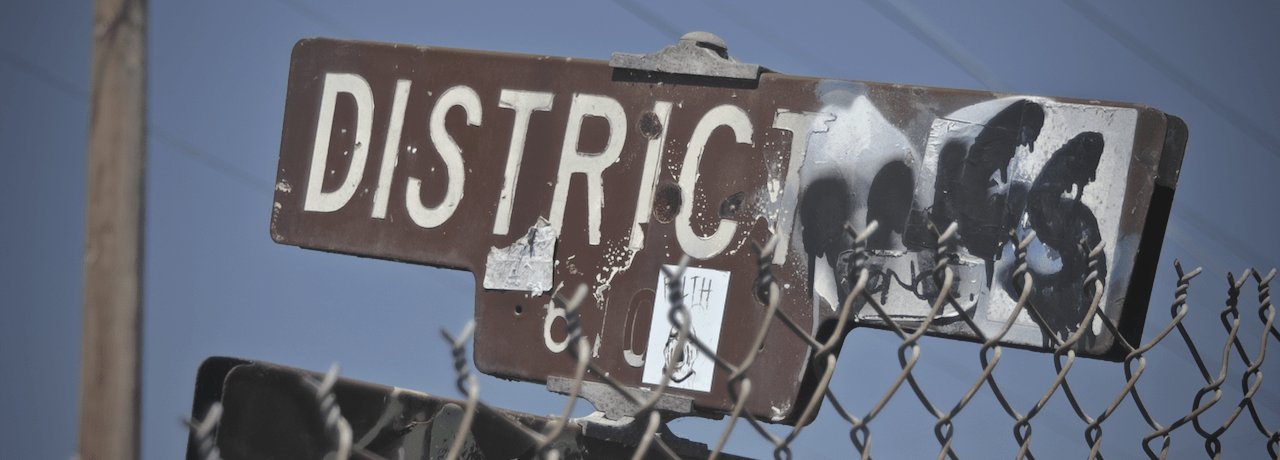 Graffitied street sign reading 'District'