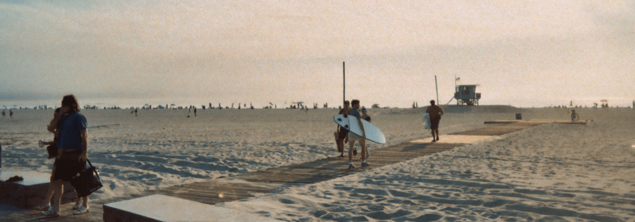 Boardwalk on the beach, with surfers on it