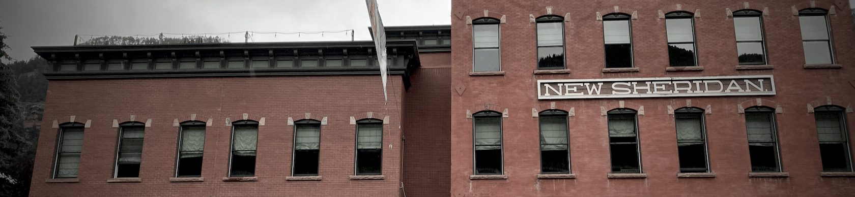 A brick 1880s building with a sign reading 'Hotel Sheridan'