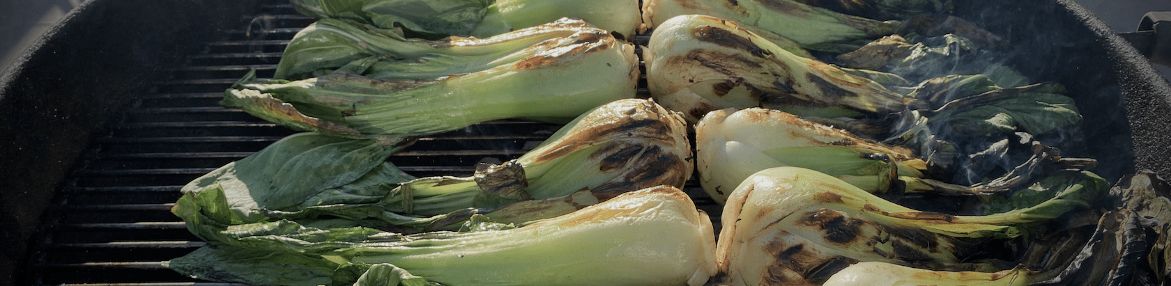 Bok Choy grilling on a charcoal kettle grill